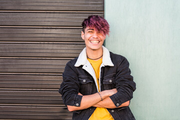 Cheerful young happy boy teenager hispanic race smile and laugh in front of the camera in posed portrait - two colors background urban style - youth teenager enjoy - violet diversity hair