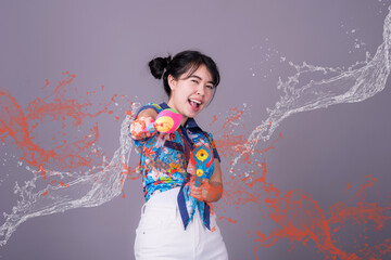 Young happy beauty Asian woman holding plastic water gun at Songkran festival, Thailand. Thai New Year's Day. Isolated on black background.