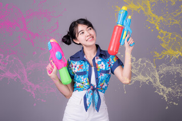 Young happy beauty Asian woman holding plastic water gun at Songkran festival, Thailand. Thai New Year's Day. Isolated on black background.