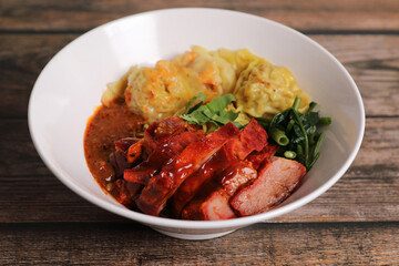 Shrimp dumpling with roasted pork with local thai tom yum spicy sauce on wood background