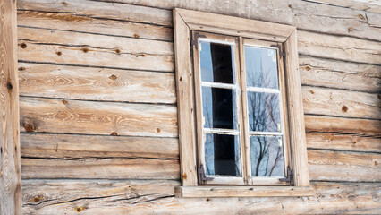 Fototapeta na wymiar Boarded up windows on the old wooden wall of the house. Carving adorns the old window. Image for design. Countryside concept.
