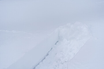 Fototapeta na wymiar Snow plow traces on white snow in winter