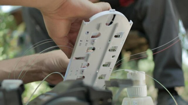 Technicians are installing optic fiber with cable ties.