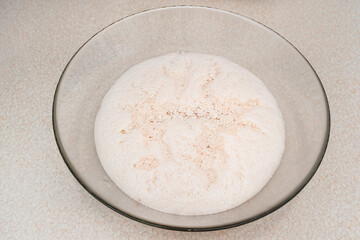 Raw, ripening yeast in a glass dish, standing on the table.