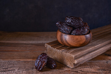 royal dates in a cup on a wooden stand with copy space