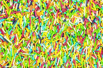 Fototapeta na wymiar Macro of easter sprinkle. Multicolored bright rainbow background. Fun colorful sweet texture. Wallpaper