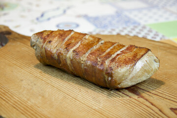 pork fillet roasted stuffed with bacon on wooden old cutting board