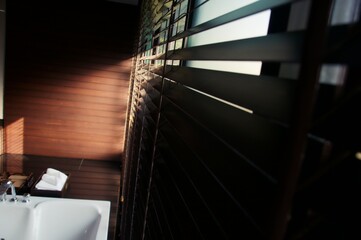 Evening sun light outside wooden window blinds, sunshine and shadow on window blinds , decorative interior home concept