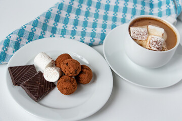 truffles with cocoa, coconut and sesame with chocolate and marshmallows and a cup of aromatic coffee, delicious dessert