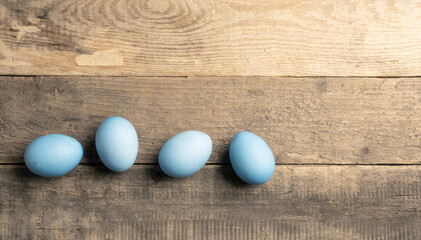 Naturally colored organic eggs in a row on a rustic table