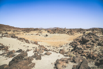 Panorama view of the Teide National Park. Rocks of volcanic origin and sand in Tenerife island, Canary Islands in Spain. Desert lunar landscape without people. Travel, adventure and freedom concept.