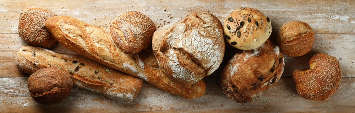 Assorted bread on wooden background, top view.