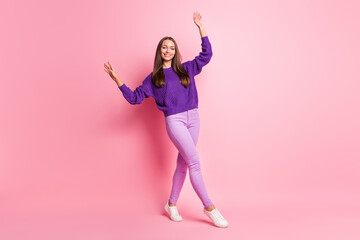 Fototapeta na wymiar Full length photo of lady dance raise hands wear purple sweater pants footwear isolated pink color background