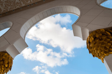 A partial view of an arch from spectacular mosque from UAE. View from below. Details from Middle Eastern or Islamic religious architecture.