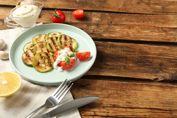 Composition with delicious grilled zucchini slices on wooden table, space for text