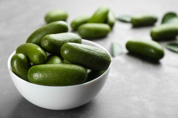 Bowl with fresh seedless avocados on grey table, closeup