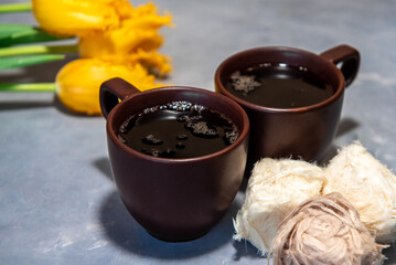 Two cups of tea or coffee with Traditional Turkish cotton candy (Pismaniye). Tea, yellow tulips on a gray background. Close-up