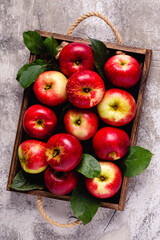 Ripe red apples in wooden box.