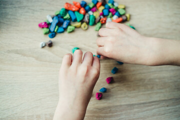 children's hands are holding colorful pebbles