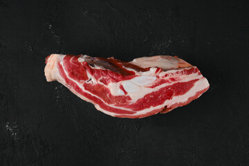 Overhead view of raw beef brisket on dark background
