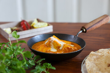 Paneer butter masala , pouring cream on Paneer tikka masala curry Delhi Mumbai North Indian vegetarian side dish Cooking butter paneer made using cottage cheese, Indian spices , footage Kerala, 