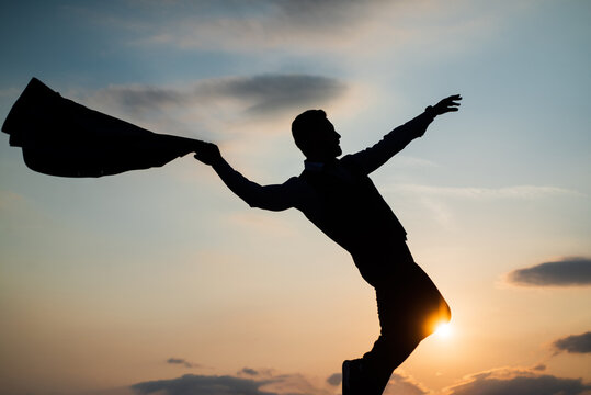 silhouette of man dancing in sense of freedom on sunrise sky, free
