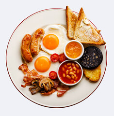 Full fry up English breakfast with fried eggs, sausages, bacon, black pudding, beans and toasts