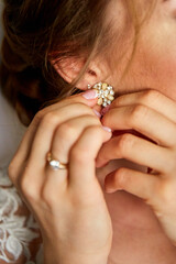 Wedding earrings on a female hand, she takes the earrings, the bride fees