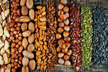 Many kinds of nuts close up. Heap of nuts on a black wooden board. Nuts are stacked on the table.