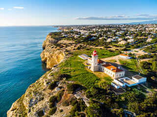 Fototapeta na wymiar Cliffy coast with Alfazinha Lighthouse in Carvoeiro, Algarve, Portugal