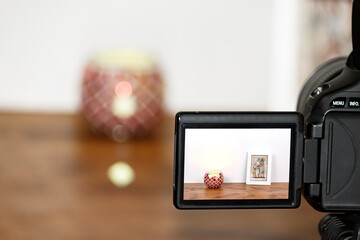 Minimalist still life seen through camera screen. Wood and white background.