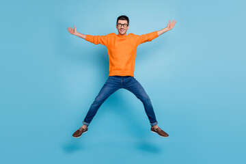 Full length photo of cheerful person jumping high have fun make star figure isolated on blue color background