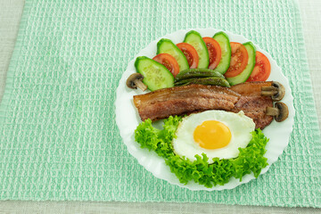 Fried eggs with bacon and fresh vegetables