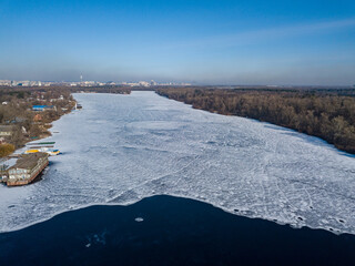 Freezing river. Aerial drone view. Sunny winter day, thin ice on the river.