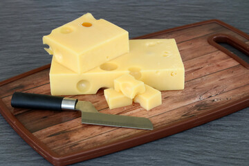 Käse mit Messer auf einem Holzbrett