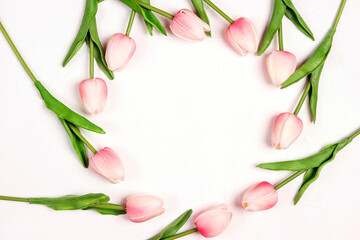 Round floral frame from tulips flowers on white background.