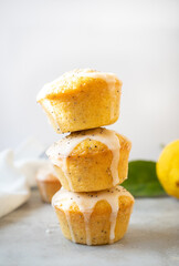 A stack of three delicious homemade lemon poppy seed muffins on bright background.