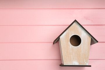 Obraz na płótnie Canvas Beautiful bird house on pink wooden background, space for text