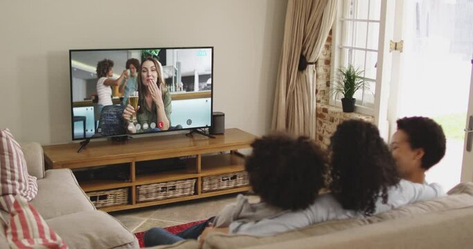African american family at home using digital tv making video call on st patrick's day