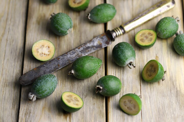 Feijoa fruits on a wooden surface. Feijoa halves and cut.