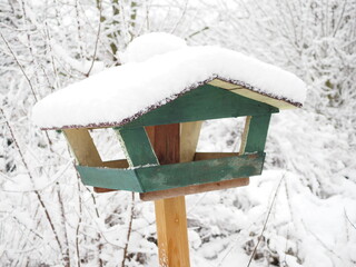 Grünes Vogelhaus zur Fütterung im Schnee