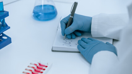 close up. scientist virologist recording test results in a journal.