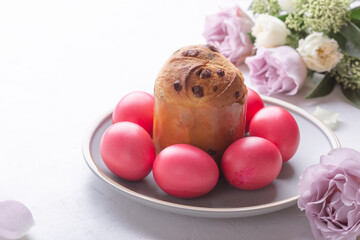 Mini panettone, natural dyed pink eggs and flowers on festive table