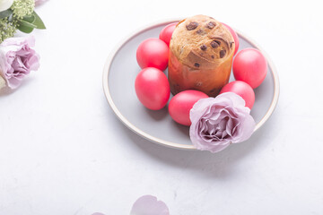 Mini panettone, natural dyed pink eggs and flowers on festive table