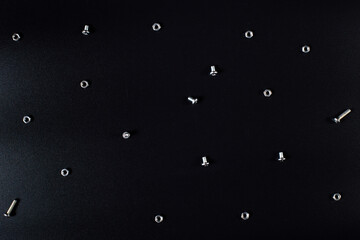 Background from hardware on black. Bolts and nuts on black background.