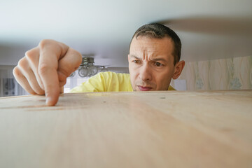 Man looks at the dirty finger from the dust. the concept of cleaning the house. a man wipes dust...