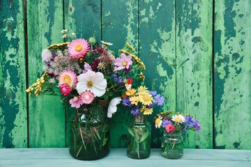 Bouquet of wild flowers in front of a rustic green wooden background - concept for birthday,...