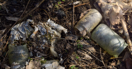 Fototapeta premium Old empty glass jars laying in the nature. Ecological catastrophe. Problems of civilization.The destruction of life and pollution.