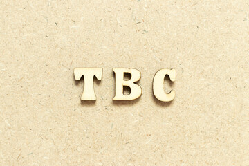 Alphabet letter in word TBC (Abbreviation of to be confirmed or continued) on wood background