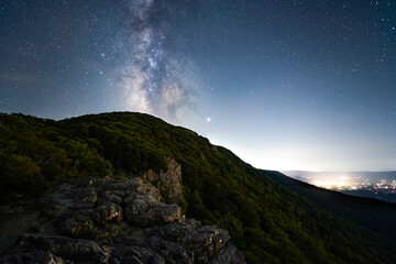 The Milky Way over Stony Man mountain with the town of Luray in Virginia providing bright light pollution, taken with a 20mm lens.